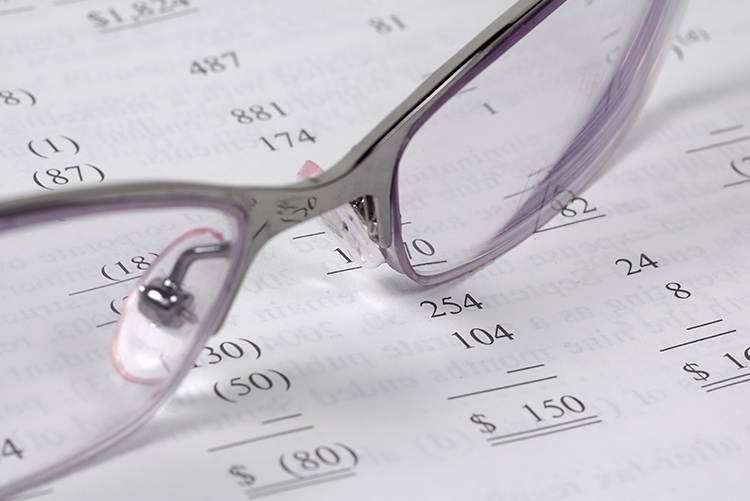 Pair of glasses resting on top of accounting documents